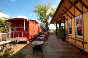 una terraza de madera con mesas y sillas en un edificio en Holiday Inn Express & Suites Bryan - College Station, an IHG Hotel en Bryan