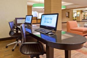 Holiday Inn Express Hotel & Suites Huntsville West - Research Park, an IHG Hotel في هانتسفيل: مكتب وبه جهاز كمبيوتر محمول فوقه