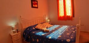 a bedroom with a bed with a blue comforter at Il Girasole in SantʼAntìoco