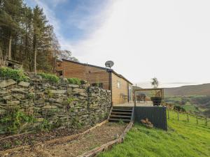 a stone retaining wall next to a house at Haka Lodge in Aberystwyth