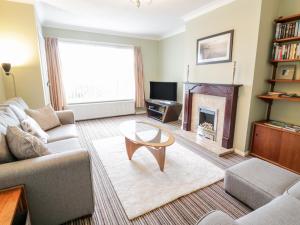 a living room with a couch and a fireplace at Castle Cove in Abergele