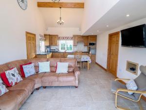 sala de estar con sofá y cocina en Bryn Eiddon, en Pwllheli