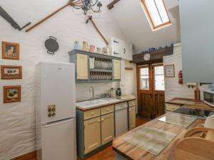 a kitchen with a white refrigerator and a sink at Heather Cottage in Milford Haven +17 photos