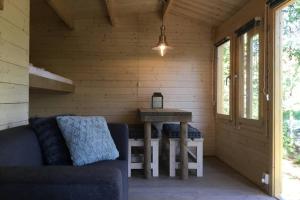 una camera con divano e tavolo in una baita di tronchi di Cozy Lodge near Brattforsheden nature reserve a Filipstad