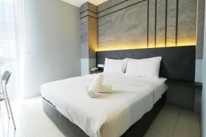 a bedroom with a bed with a white towel on it at Suite Dreamz Hotel in Kuala Lumpur