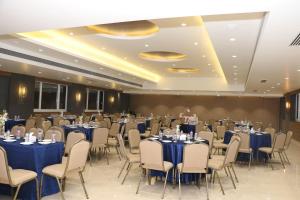 马尔冈Cosmique Clarks Inn Suites Goa的摆放着蓝色桌椅的宴会厅