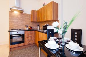 a kitchen with wooden cabinets and a table with glasses of wine at All2Stay South Kensington Apartment in London