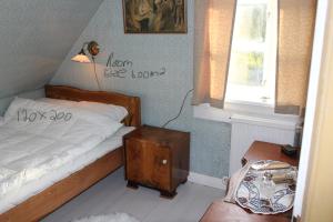 a bedroom with a bed and a nightstand and a window at Cosy Guesthouse anno 1936 in Sandavágur