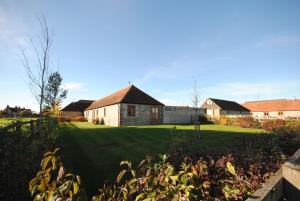 a large yard with a house in the background at The Run, West Lavant in Chichester