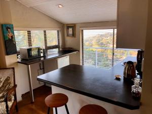 eine kleine Küche mit einer schwarzen Arbeitsplatte und einem Fenster in der Unterkunft Winston House in Durban