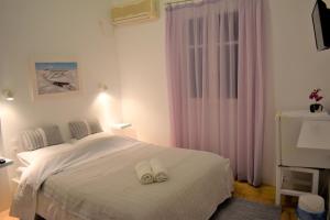 a bedroom with a bed with two white towels on it at Angeliki Pension in Katapola