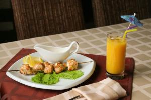 a plate of food and a glass of orange juice at Oskar in Pereslavl-Zalesskiy