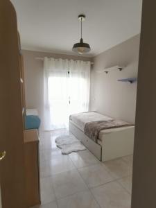 a bedroom with a bed and a window at Penha House in Faro