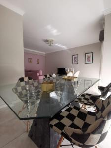 a dining room with a glass table and chairs at Penha House in Faro