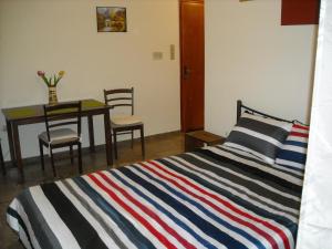 1 dormitorio con 1 cama y 1 mesa con sillas en Kalamata home, City centre en Kalamata