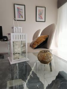 a living room with a glass table and a chair at Penha House in Faro