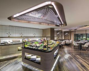 a buffet line with food on display in a restaurant at Narcissus Al Hamra Hotel Jeddah in Jeddah