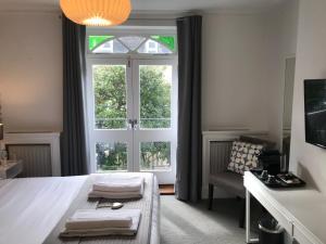 a bedroom with a bed and a large window at The White House in Brighton & Hove