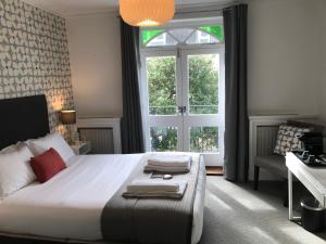 Un dormitorio con una cama grande y una ventana en The White House, en Brighton & Hove