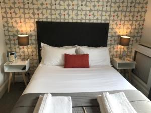 1 dormitorio con cama grande y almohada roja en The White House, en Brighton & Hove