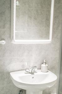 ein Badezimmer mit einem weißen Waschbecken und einem Spiegel in der Unterkunft Apartamento CaMaría Castillo 2º in Peñíscola