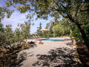 een zwembad in een tuin met bomen bij Belvilla by OYO Villa il Castello in Castiglion Fiorentino