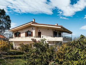 a house on the side of a hill at Holiday villa with sea view in Paralia Avlidas in Dhílesi