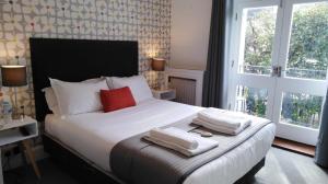 a bedroom with a large bed with towels on it at The White House in Brighton & Hove
