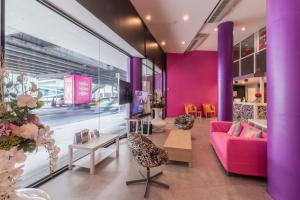 a living room with a pink couch and chairs at 63 Bangkok Hotel in Bangkok