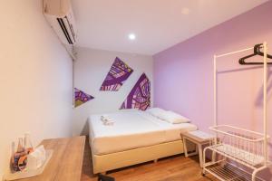 a bedroom with a bed with purple walls at 63 Bangkok Hotel in Bangkok