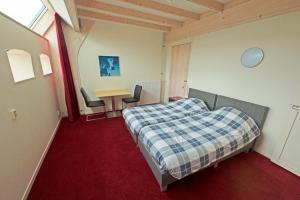 a bedroom with a bed and a table and chairs at Gast op stal nabij Leeuwarden in Wyns +79 photos