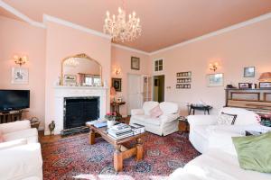 a living room with white furniture and a fireplace at The Old School in Bicester