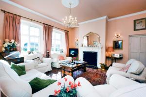 a living room with white furniture and a fireplace at The Old School in Bicester