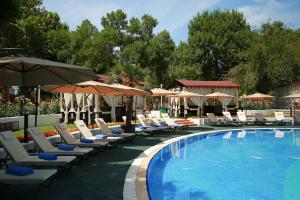 a swimming pool with lounge chairs and umbrellas at Wyndham Tashkent in Tashkent