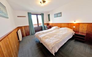 a bedroom with a large bed and a window at Chalethotel Belle Etoile in L'Alpe-d'Huez