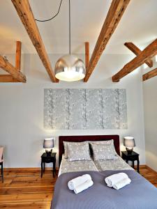 a bedroom with a blue bed and a ceiling with beams at Berni's home Apartament z tarasem in Sopot