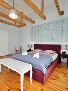 a bedroom with a large bed and wooden floors at Berni's home Apartament z tarasem in Sopot