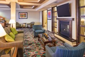 Holiday Inn Express & Suites El Paso Airport, an IHG Hotel في الباسو: غرفة معيشة مع موقد وتلفزيون