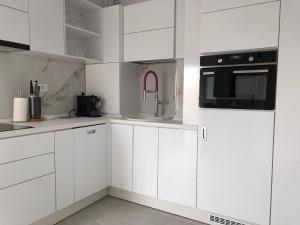 a white kitchen with white cabinets and appliances at Luxury Westpark 2-Room Apartment Lakeview W5 in Bucharest
