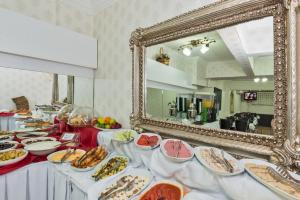 ein Buffet mit Speisen und einem Spiegel in der Unterkunft Le Safran Palace Hotel in Istanbul