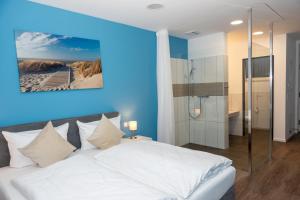 1 dormitorio con cama blanca y ducha en LOK - Die Pension - Das Restaurant en Tessin