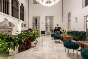 uma sala de estar com mesas, cadeiras e plantas em BiBo Suites Oro del Darro em Granada