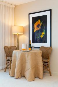 a table with a bottle of wine and two chairs at Bayview Hotel in Bar Harbor +8 photos