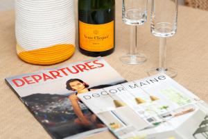 a magazine next to wine glasses and wine bottles at Bayview Hotel in Bar Harbor