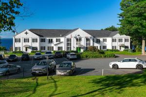 a large white building with cars parked in a parking lot at Bayview Hotel in Bar Harbor