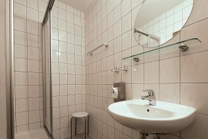 Un baño blanco con lavabo y espejo. en Gasthof Mühle, en Lübbenau