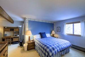 a blue bedroom with a bed and a desk and a window at Katsos Ranch Retreat in Vail