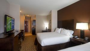 a hotel room with a bed and a flat screen tv at Holiday Inn Express Hotel and Suites Elk City, an IHG Hotel in Elk City