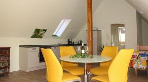 uma sala de jantar com uma mesa e cadeiras amarelas em Gräfin von Paris - Appartement mit Saunanutzung em Burgbernheim