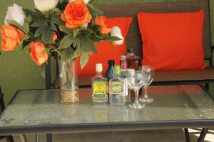 a table with a vase of flowers and wine glasses at Ochi Rios Drax Hall 3 bed sleeps 7 Exquisitely fully furnished accommodations in Ocho Rios